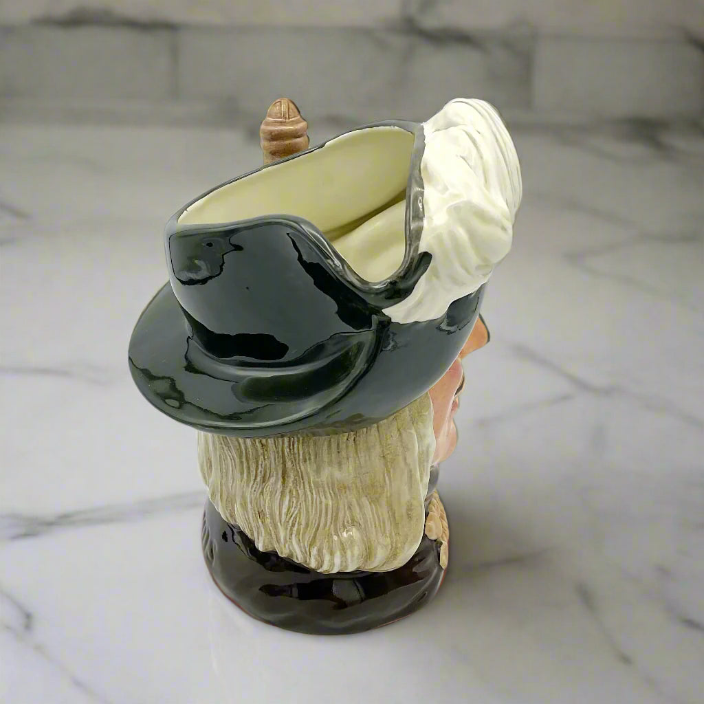 Side view of Large Aramis China collectible toby jug on marble background.