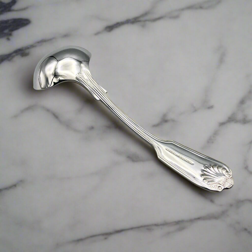 Silver plated ladle upside down on a marble worktop