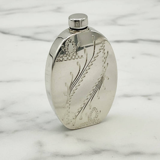 Small Sterling Silver Scent Bottle with engraved design on a marble surface