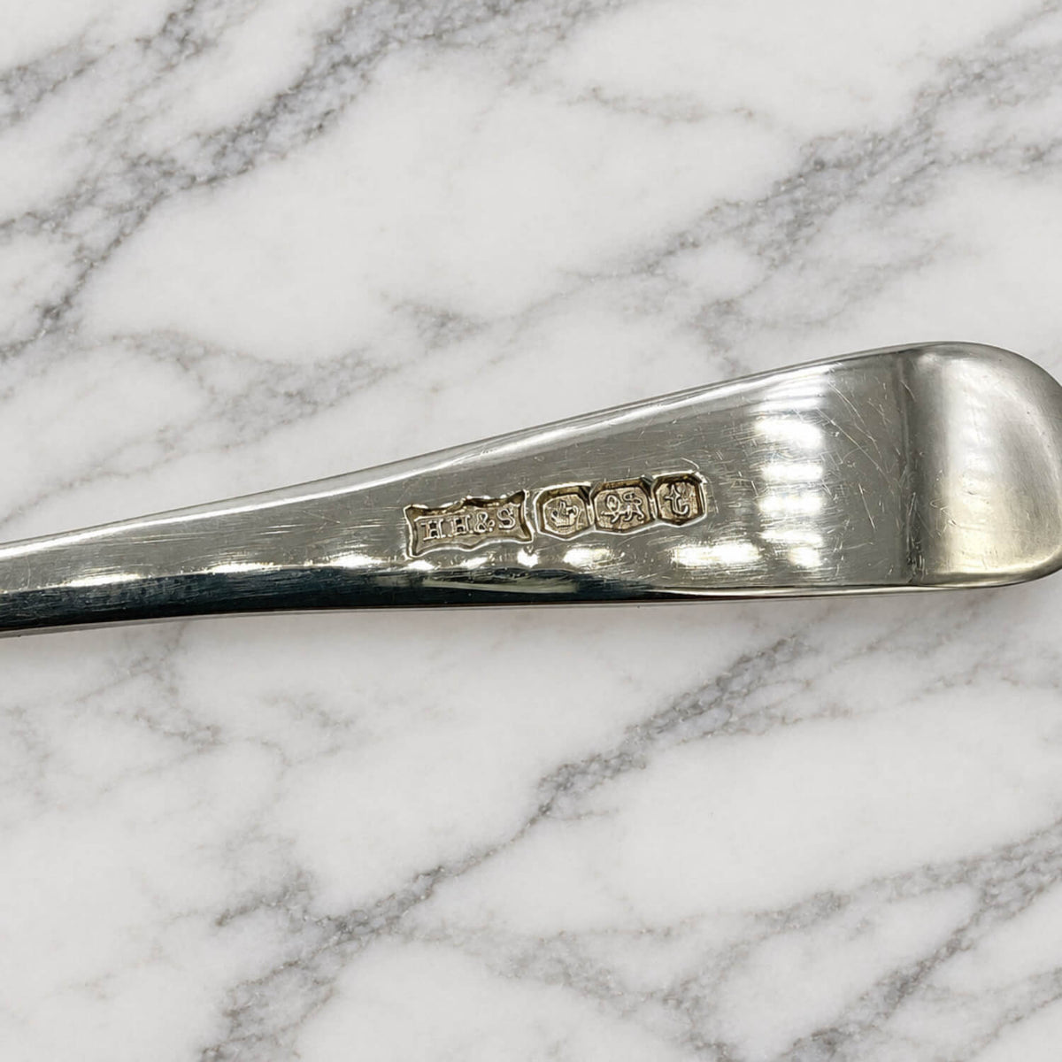 Sterling Silver Egg spoon hallmarks against a marble background