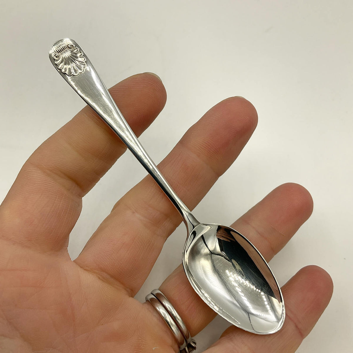 Sterling Silver Egg Spoon held in a hand on a white background