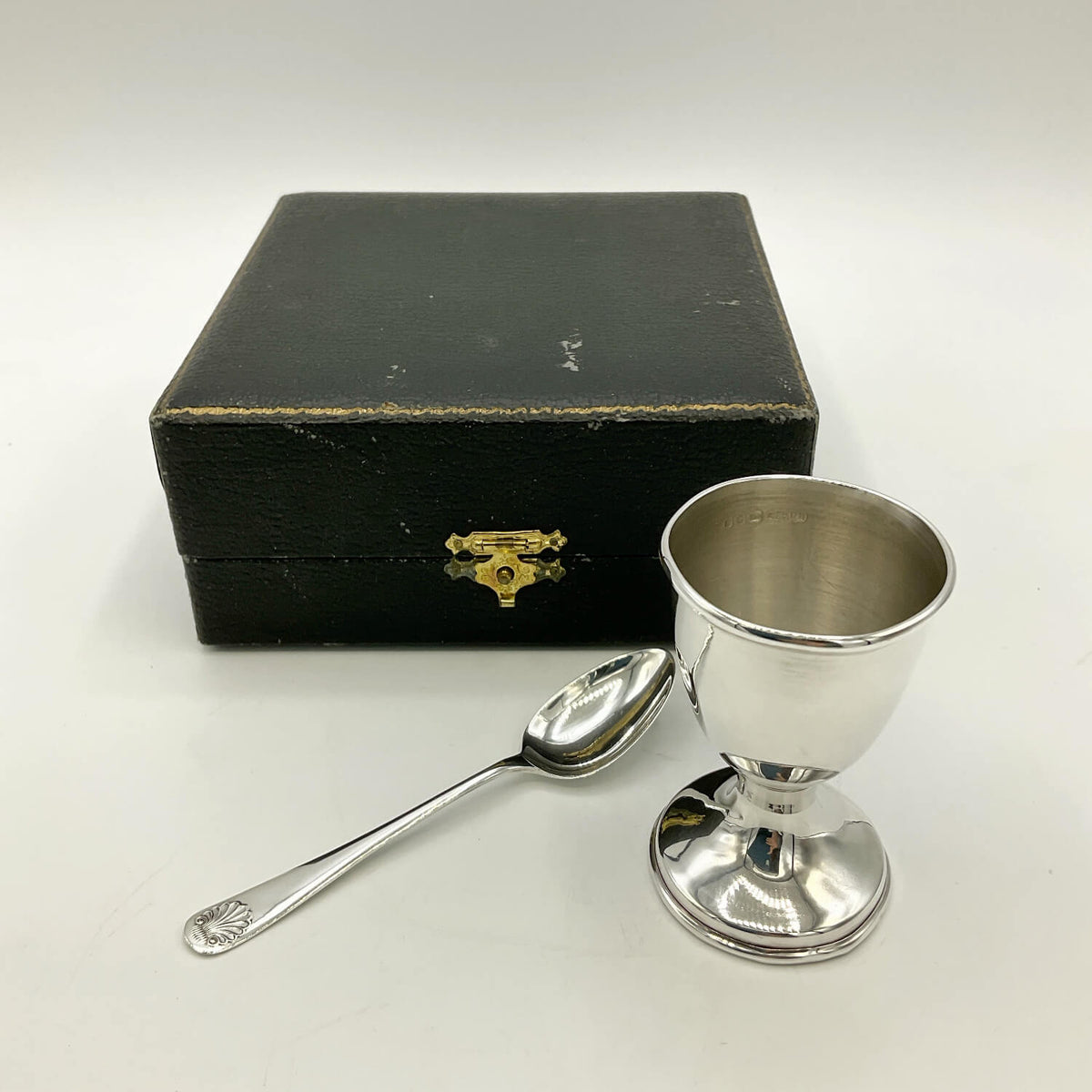 Sterling Silver Egg Cup and Spoon next to a black presentation box