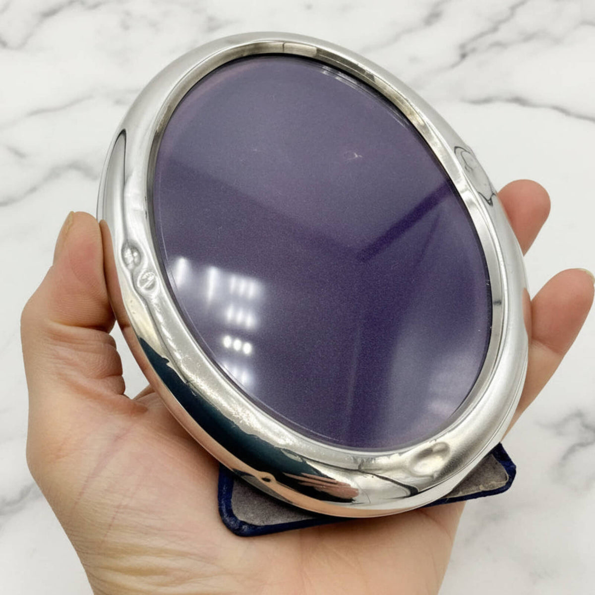 Sterling Silver Oval Photo Frame held in a hand with a marble background