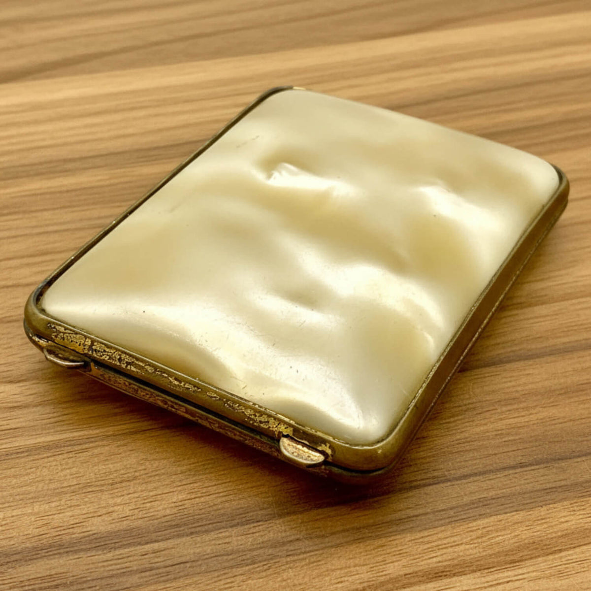 Vintage gold and cream-coloured case on a wooden surface