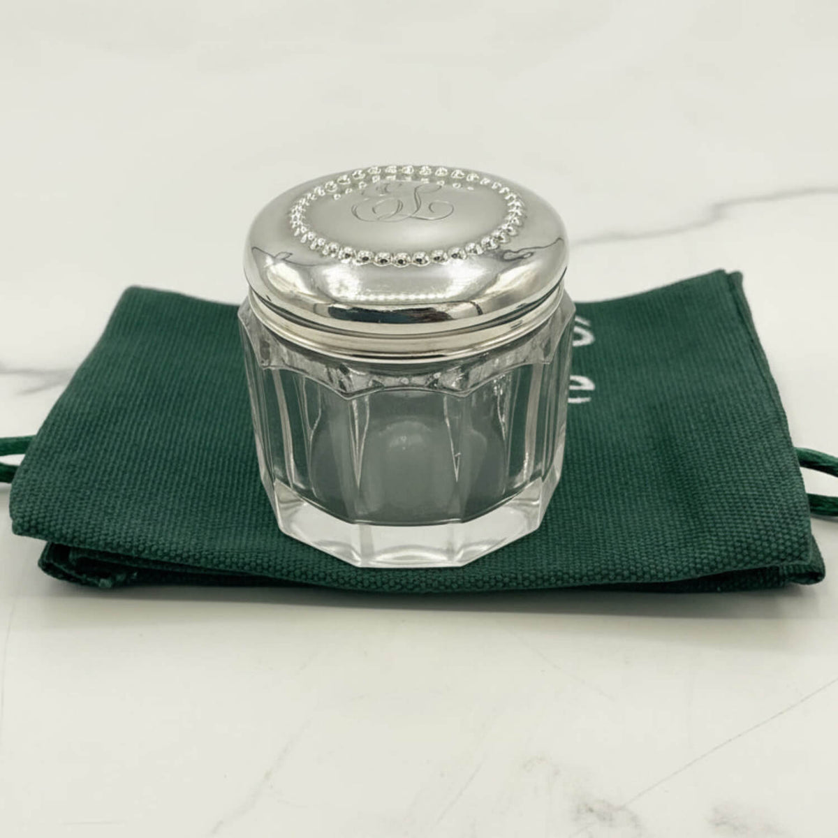 Glass jar with silver lid on a green cloth