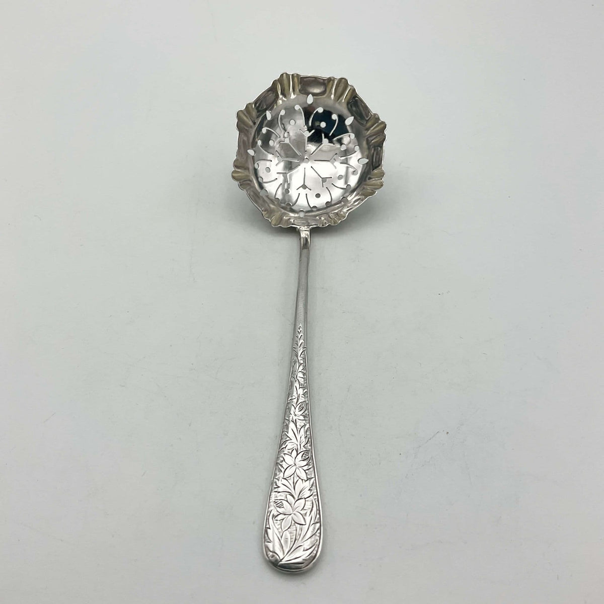 Decorative silver sugar sifter on a wooden surface