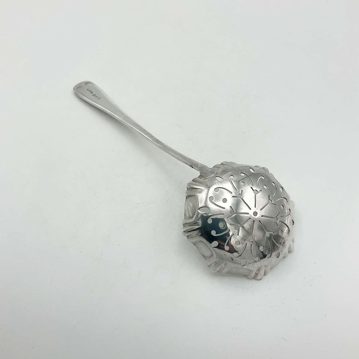 Silver decorative sugar sifter spoon on a white background