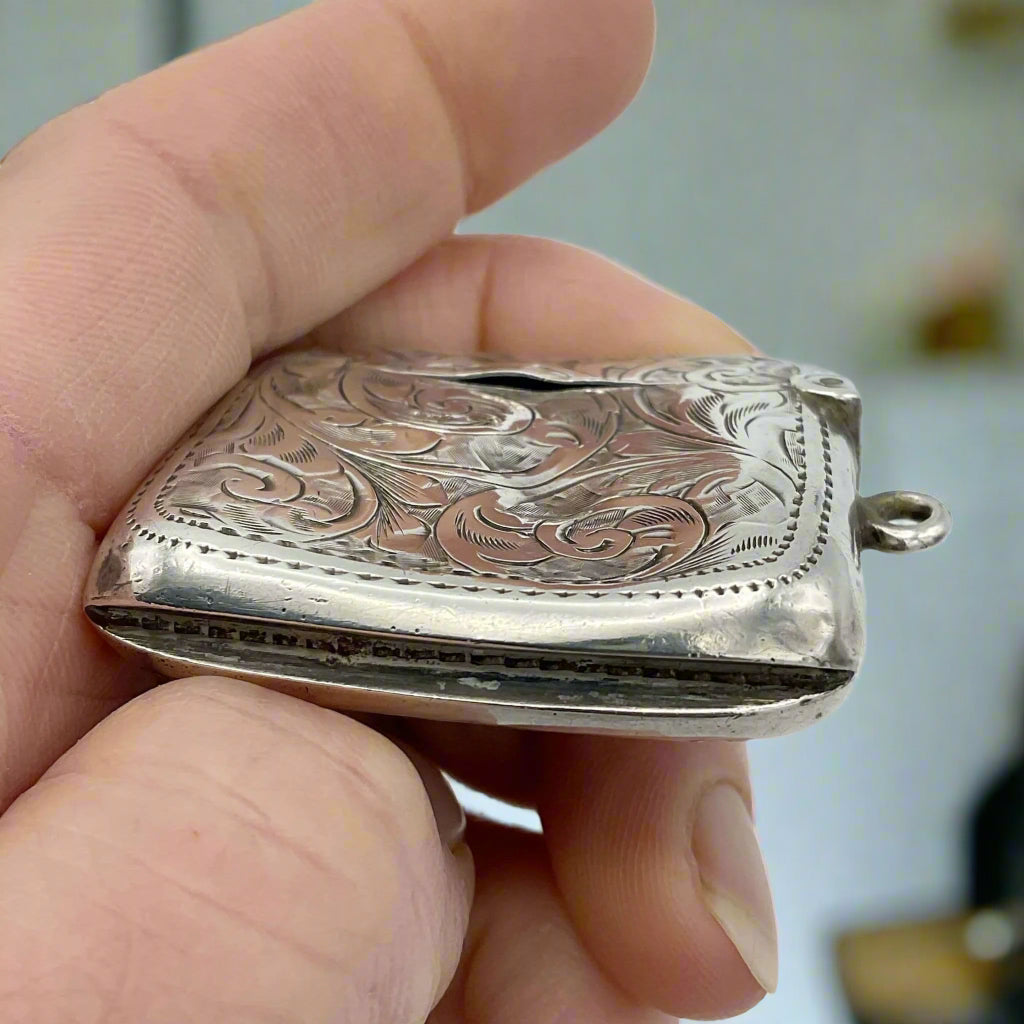 Silver Vesta held in hand with a kitchen in the background 