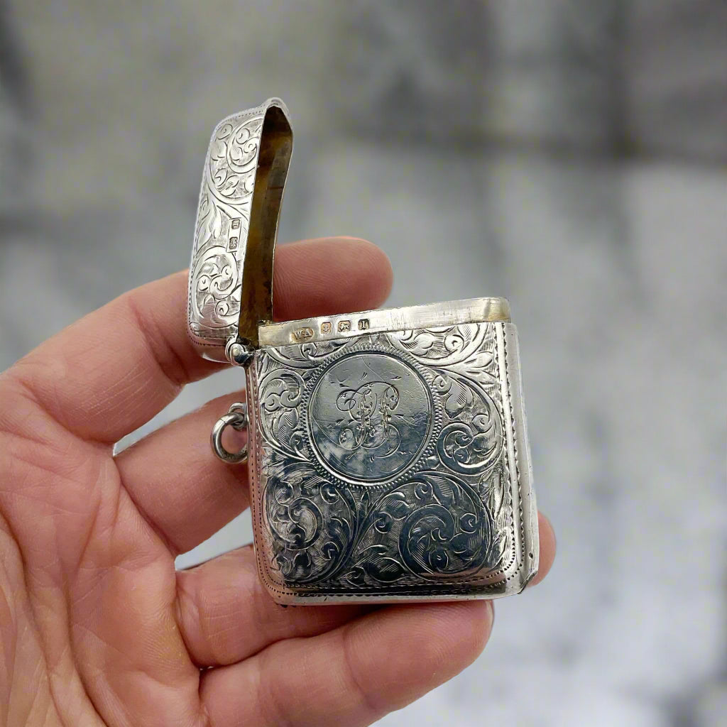 Silver Vesta case in hand with marble worktop in background 