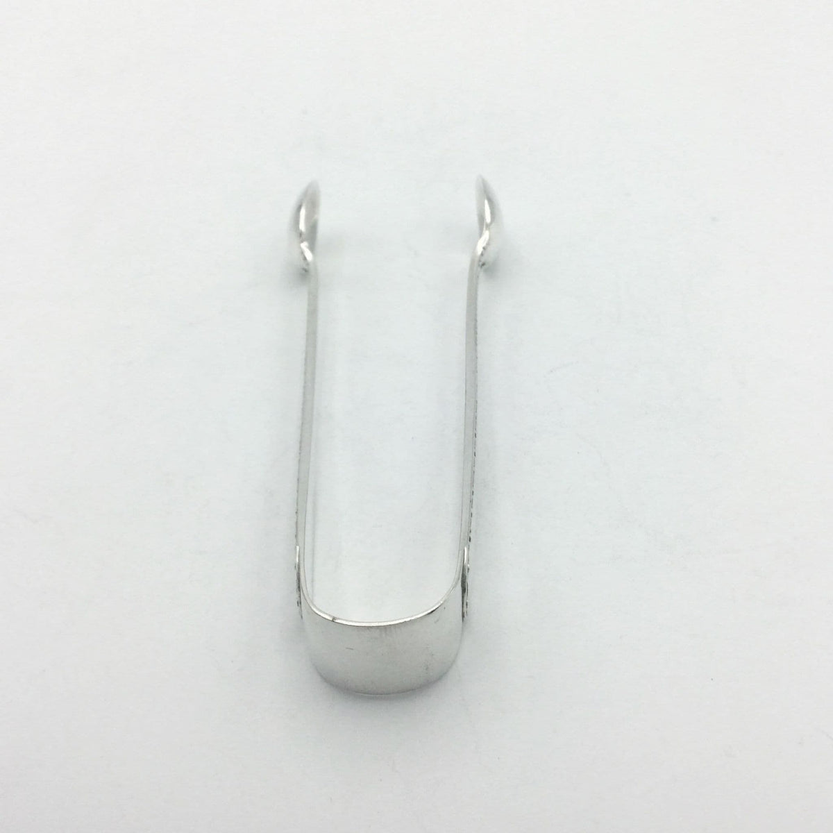 silver plated sugar tongs pointing away from the camera 