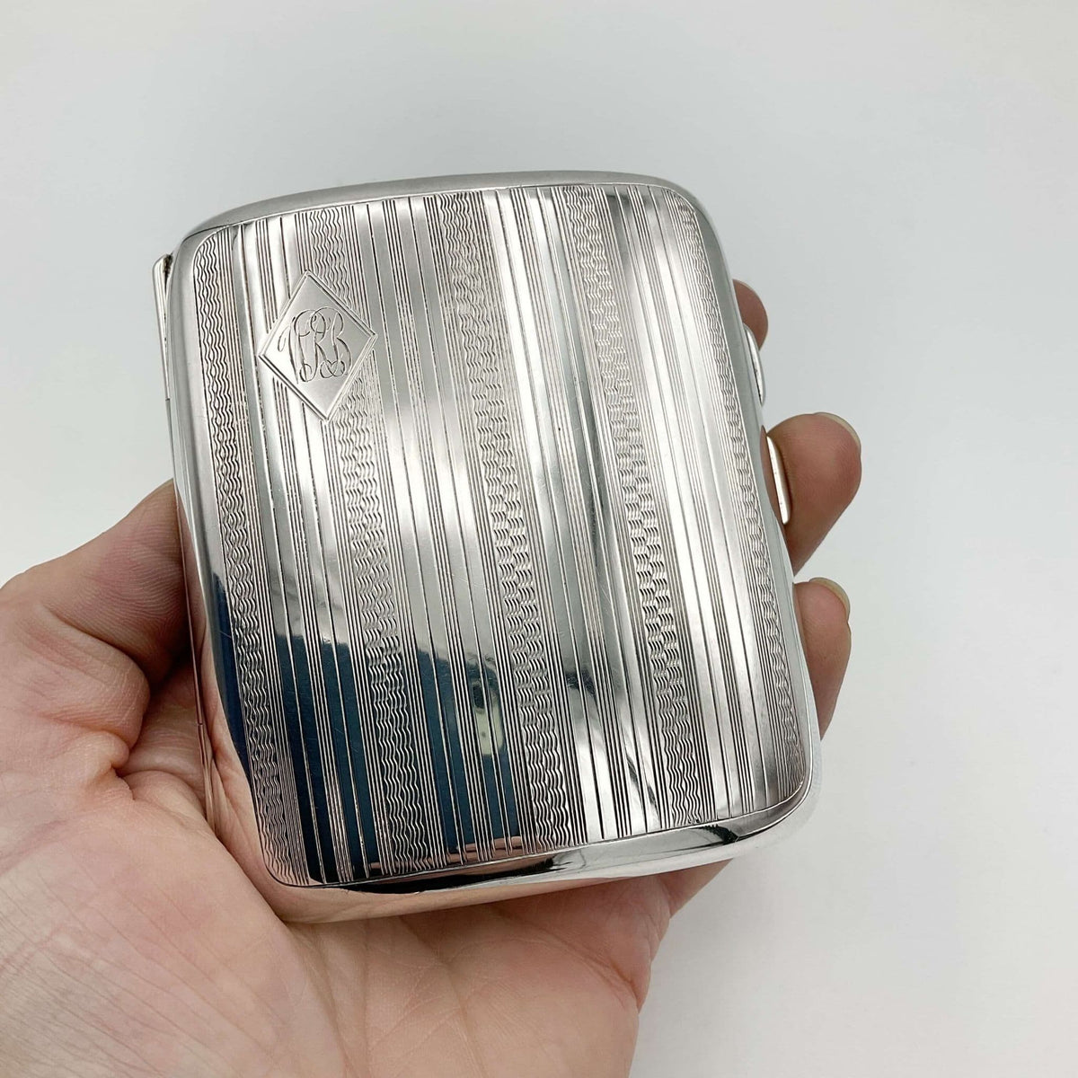 Antique 1920s shiny silver cigarette case held in a hand