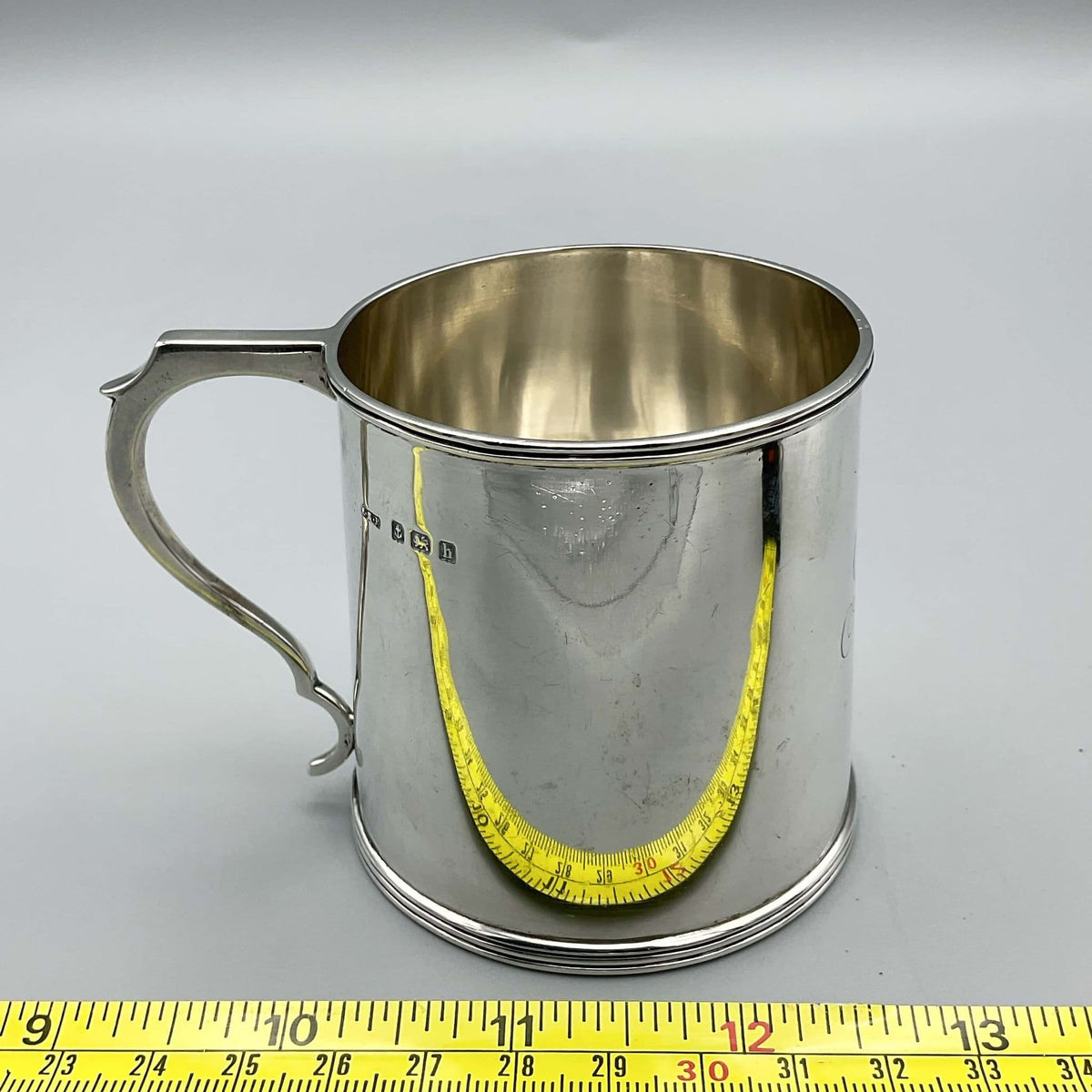 Antique Edwardian silver Christening Cup with hallmarks from 1907, featuring intricate engravings and vintage craftsmanship.