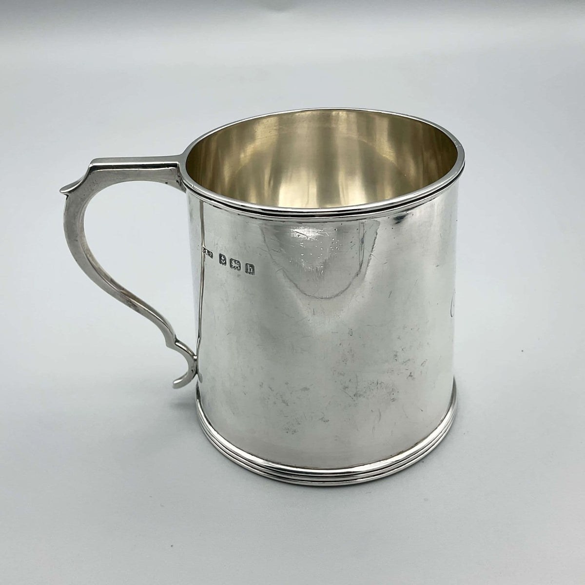 Antique Edwardian silver Christening Cup with hallmarks from 1907, featuring ornate engraved design and delicate craftsmanship.
