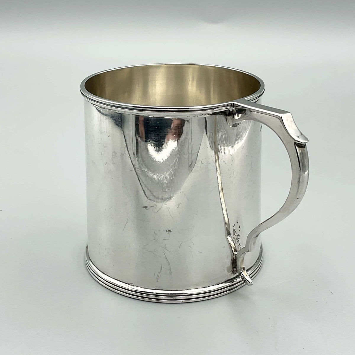 Antique Edwardian silver Christening cup hallmarked 1907 with ornate engraved design and a rounded base.