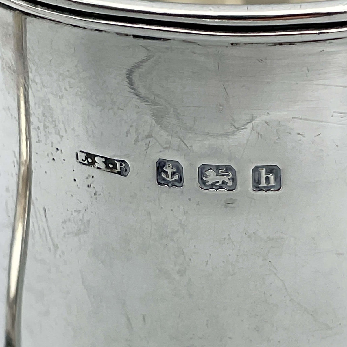 Antique Edwardian silver Christening Cup with hallmarks from 1907, ornate design, displayed on a wooden surface.