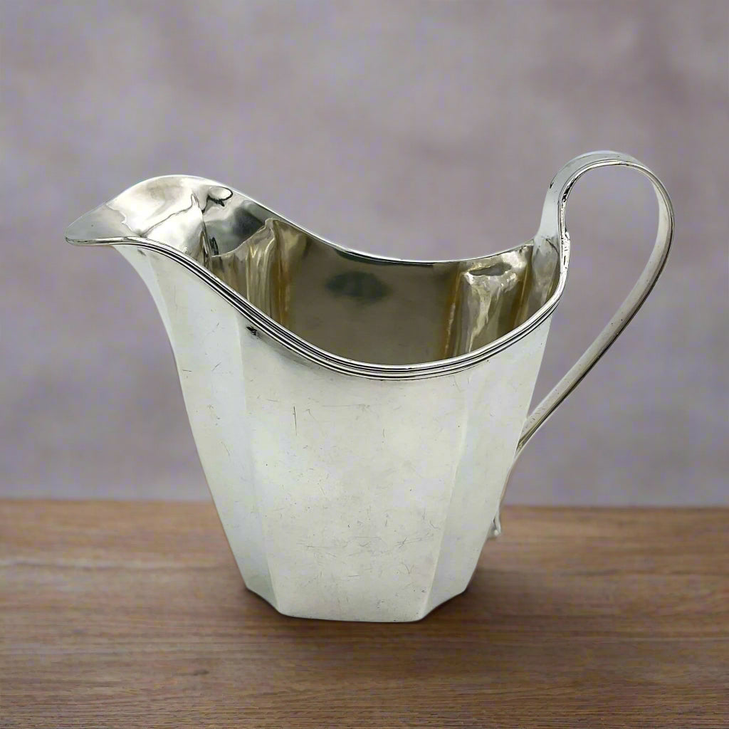 Antique silver jug on a wood table