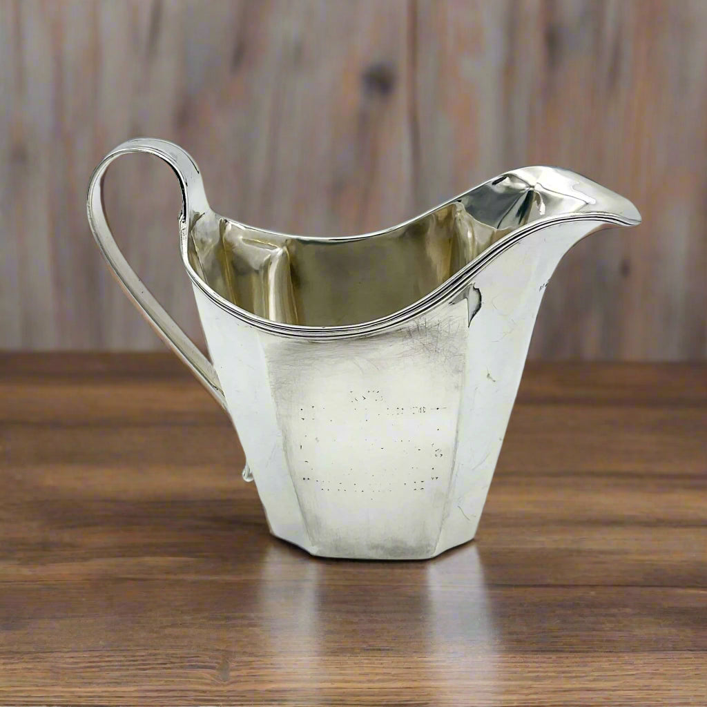 Silver jug on a wood able
