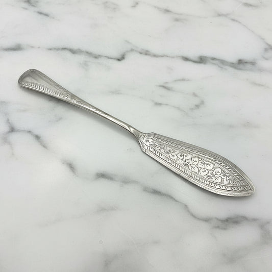 Antique silver plated butter knife with ornate design and EP stamped on the back of the handle, showing some wear on a marble surface