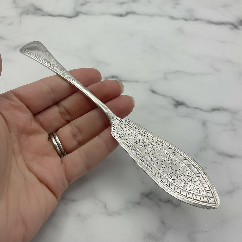 butter knife held in a hand with a marble background