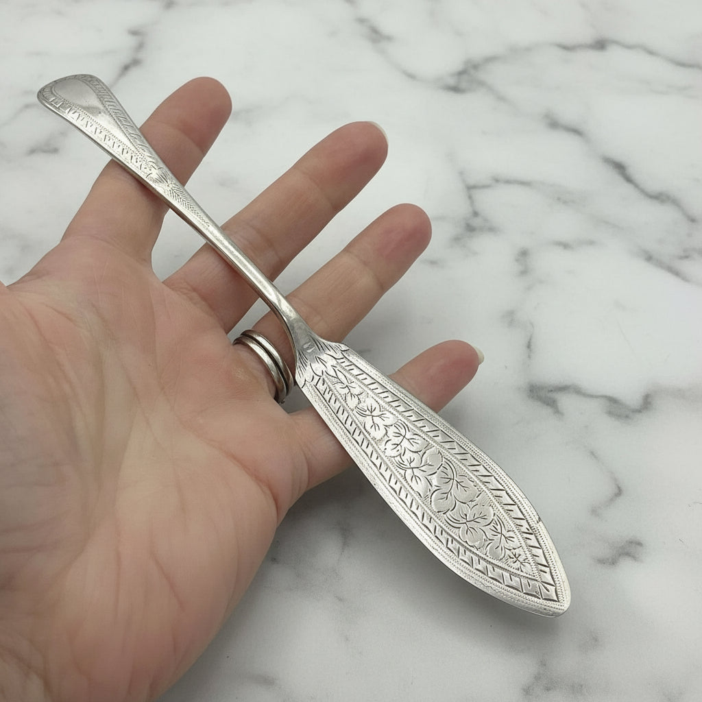 butter knife in a hand with a marble background