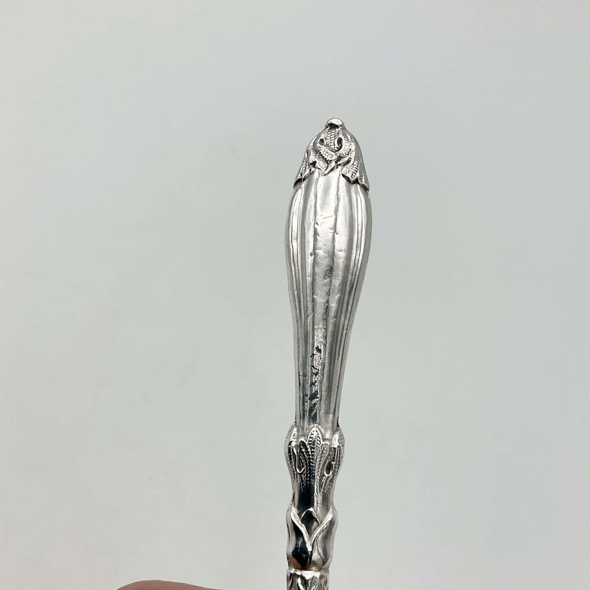 Antique silver plated pickle fork with an ornate handle 