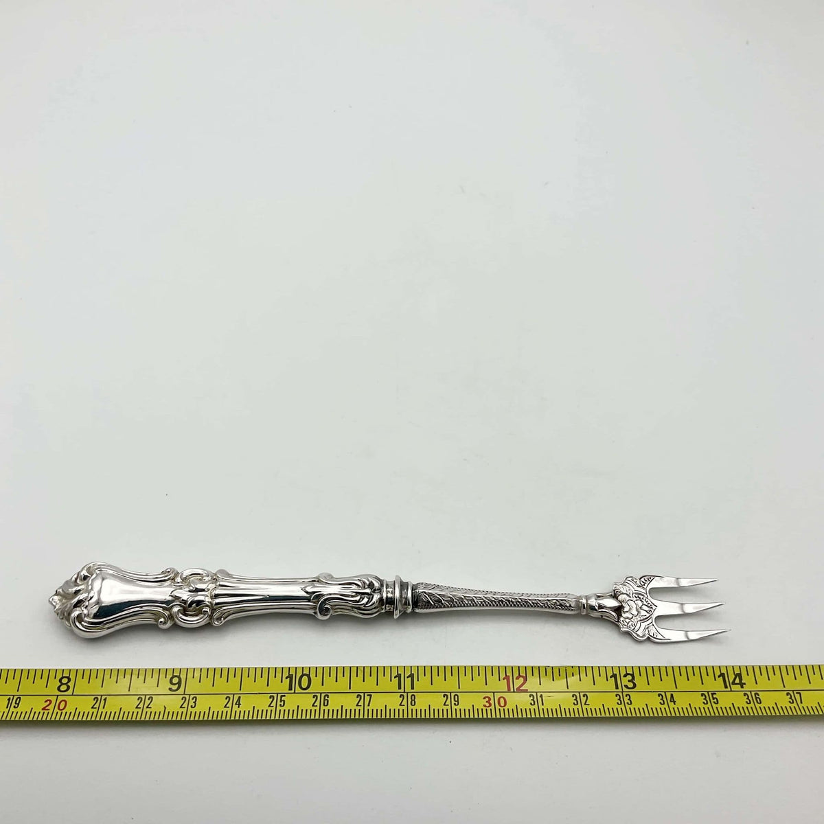 Antique Pickle fork next to tape measure showing it to be 16.5cm in length