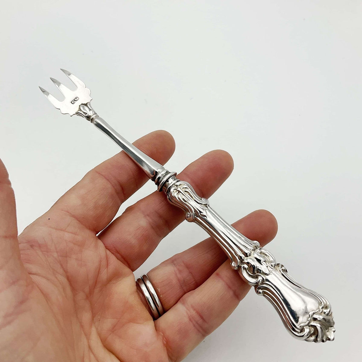 Antique silver pickle fork upside down with GU on end