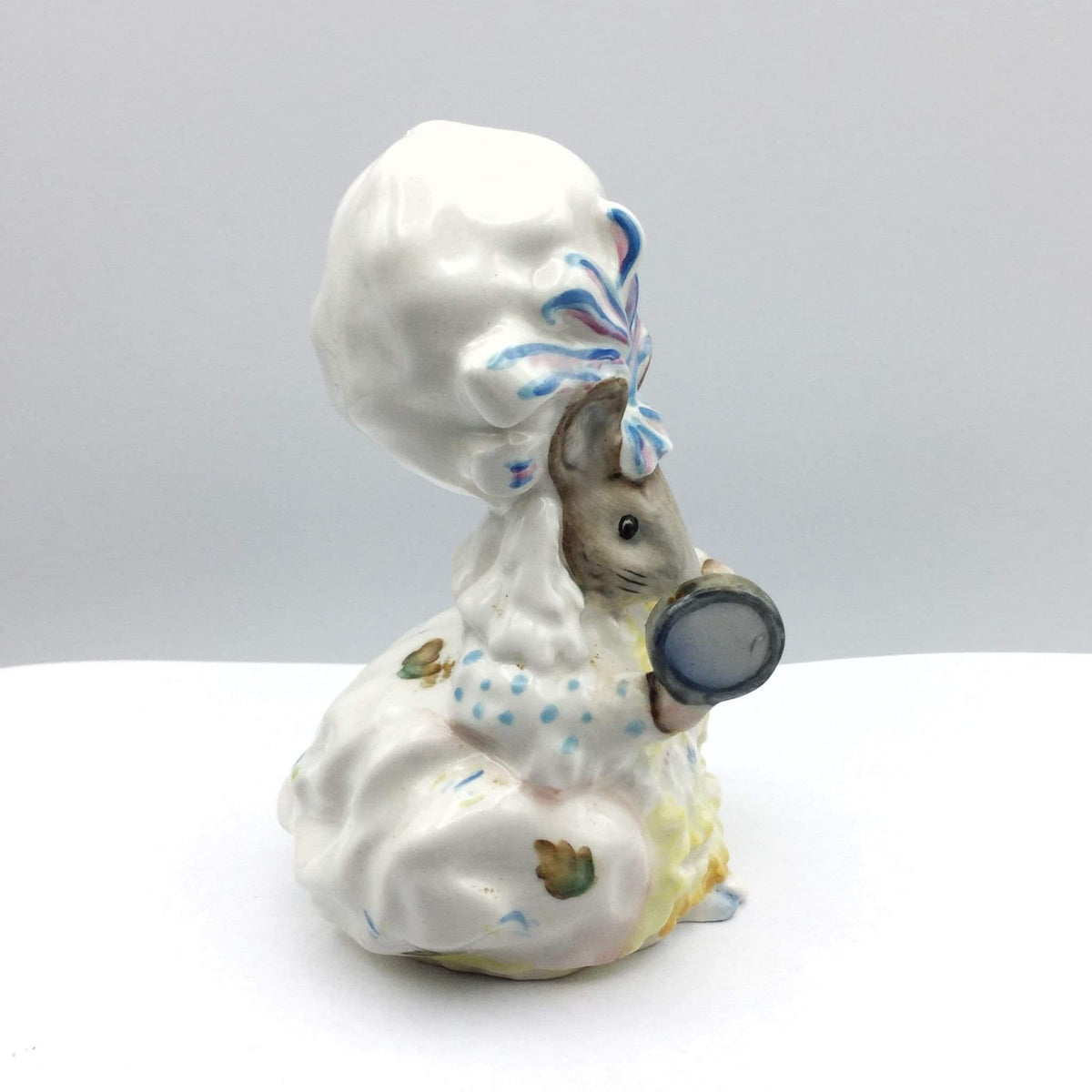 Decorative figurine of a mouse with a chef's hat and oversized spoon on a white background