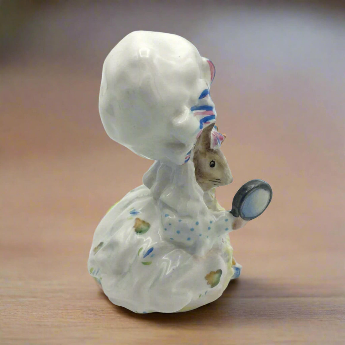 Ceramic figurine of lady mouse on a wooden surface