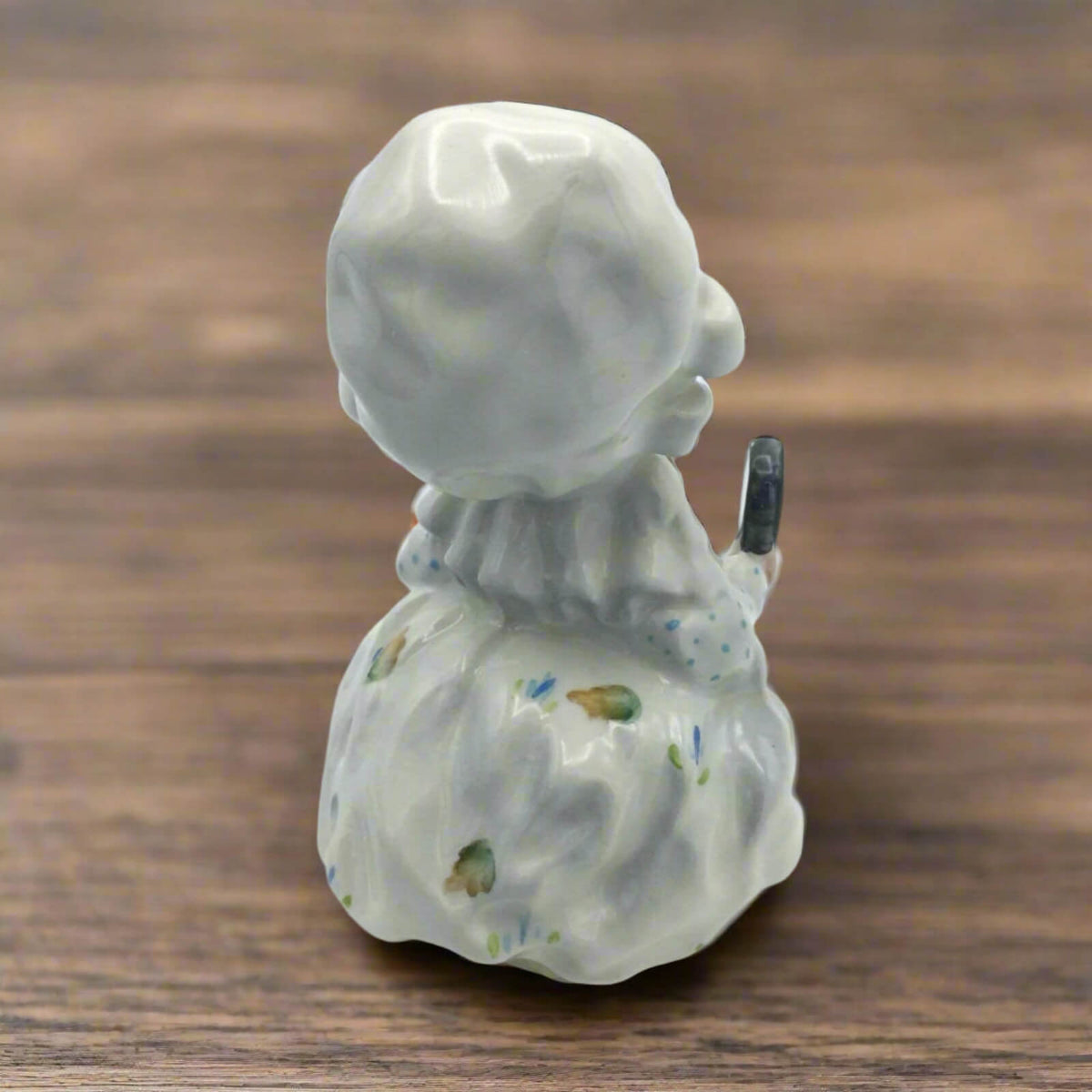 Ceramic figurine of lady mouse with a mirror, on a wooden surface