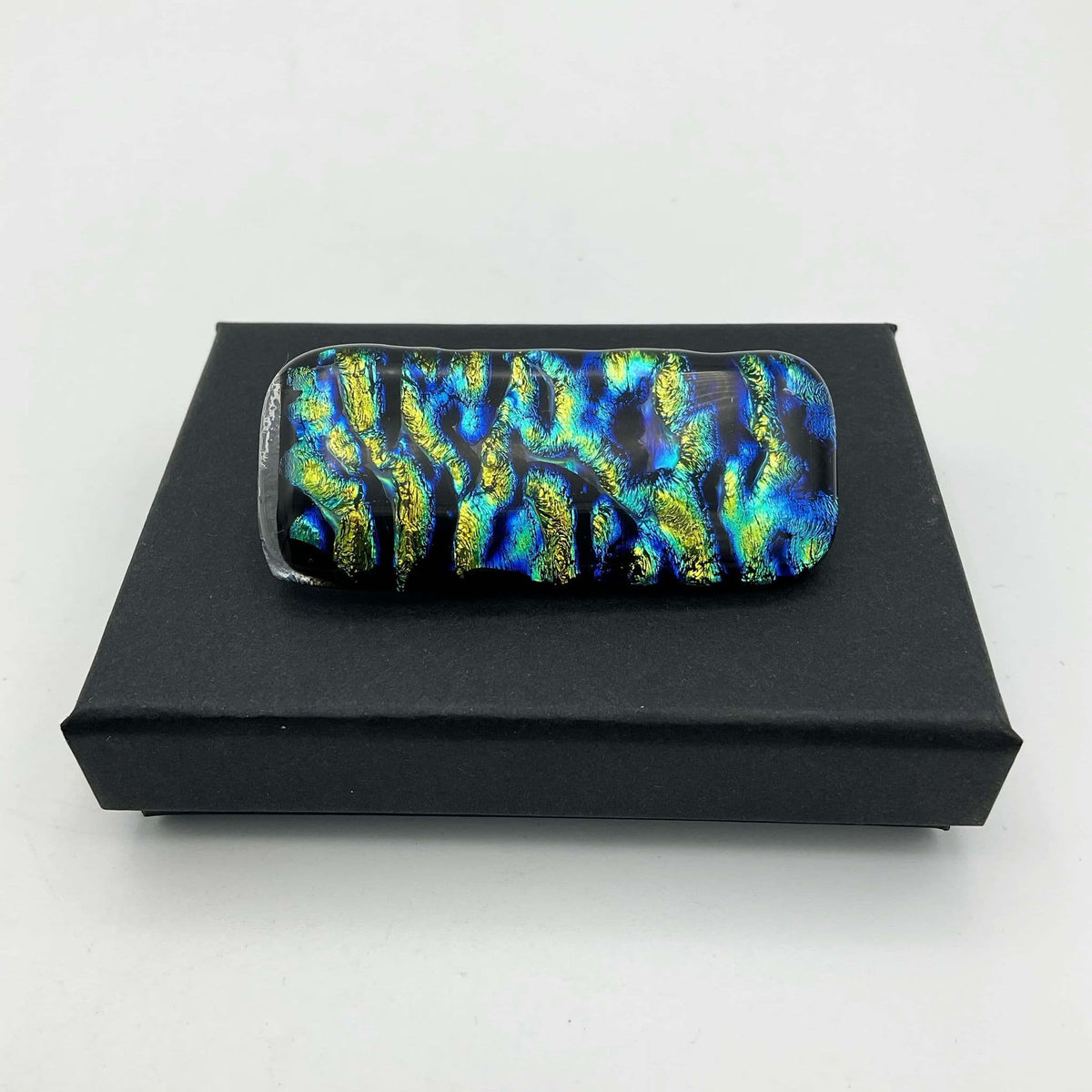 Blue and yellow glass brooch featuring a vintage beeches design, with vibrant colors and intricate glasswork.