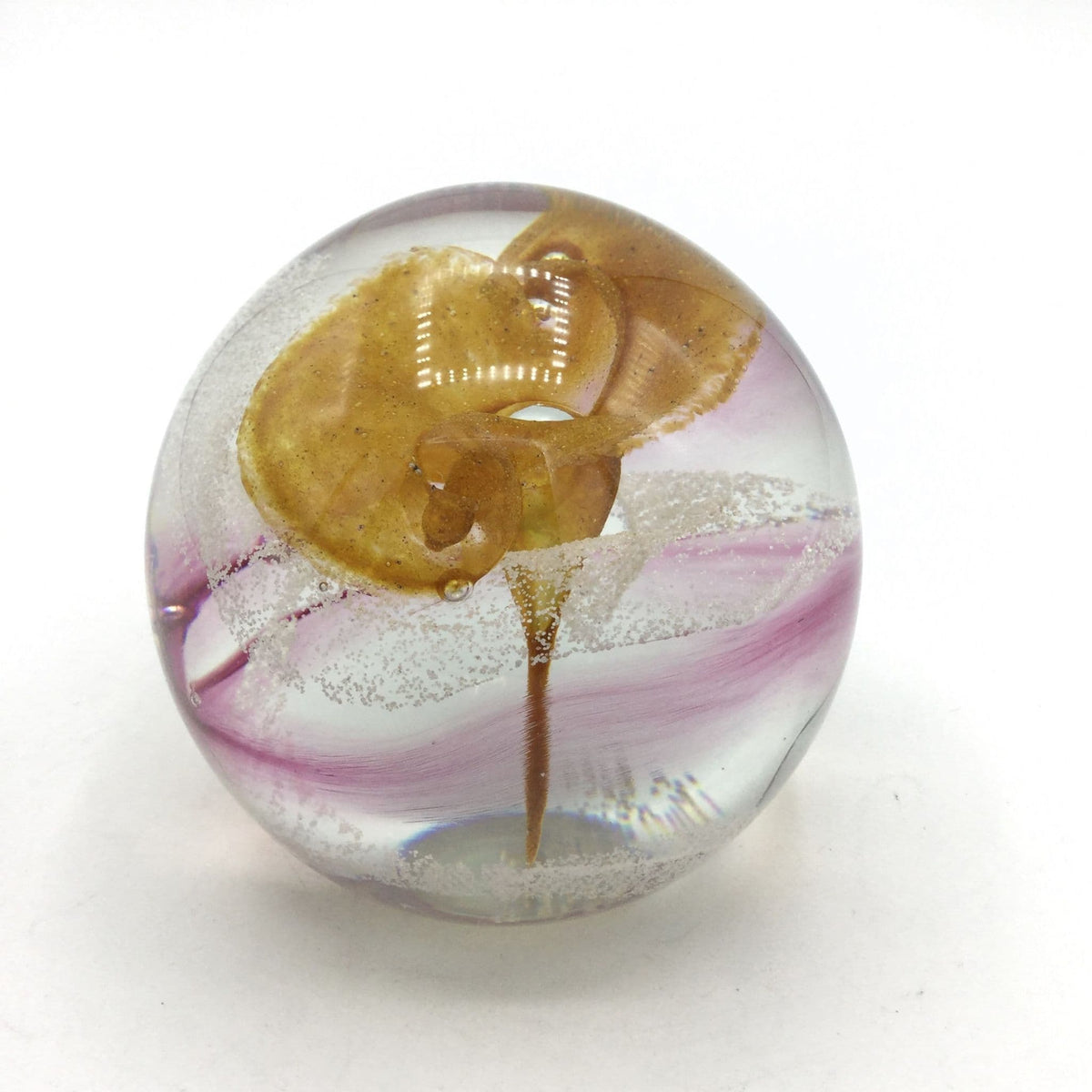 Caithness paperweight with an orange flower and pink swirl on a white background