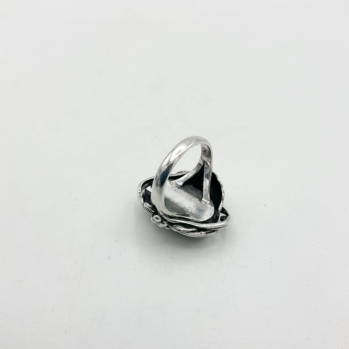 Silver ring upside down on white background showing silver band