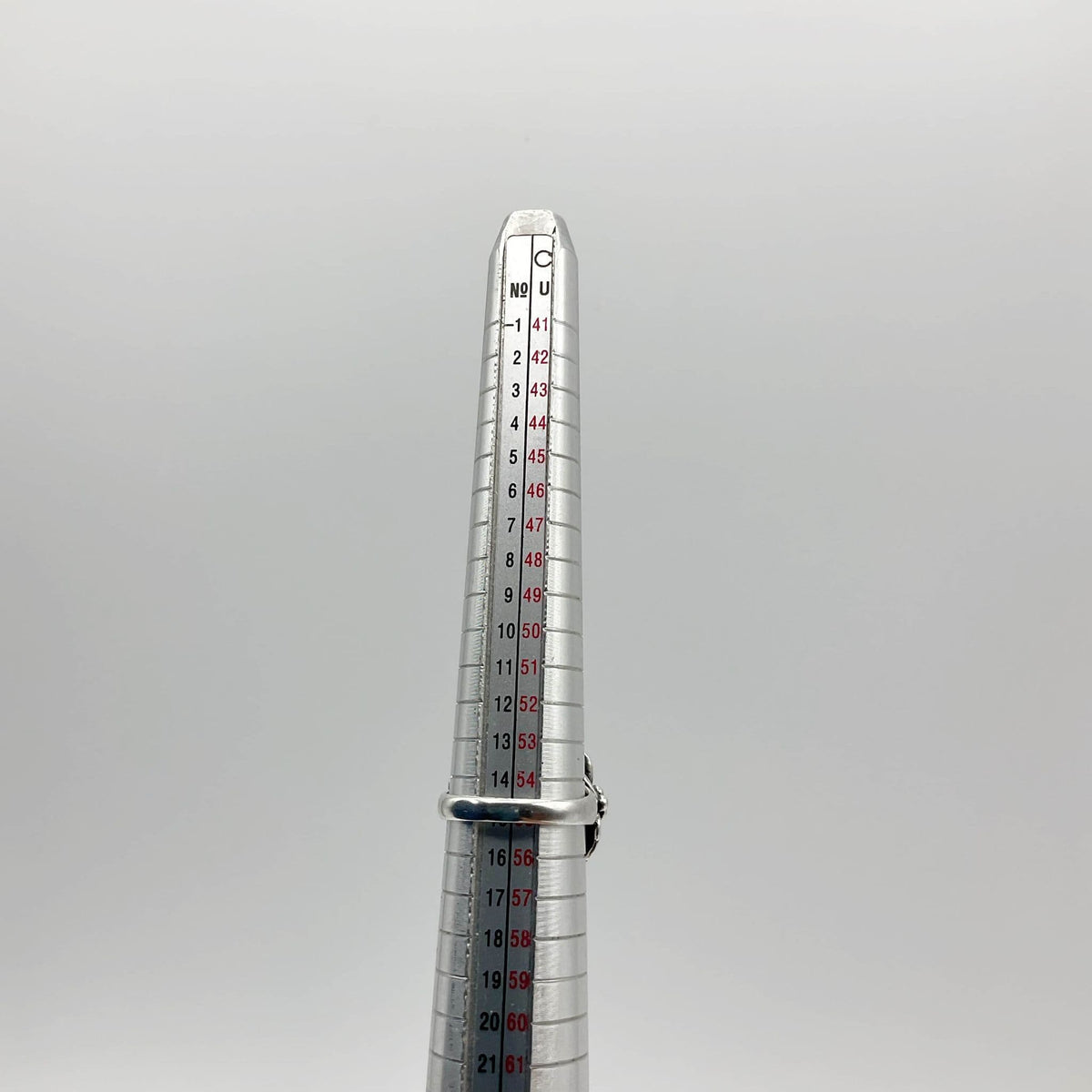 Silver ring on measuring stick showing size 55 EU