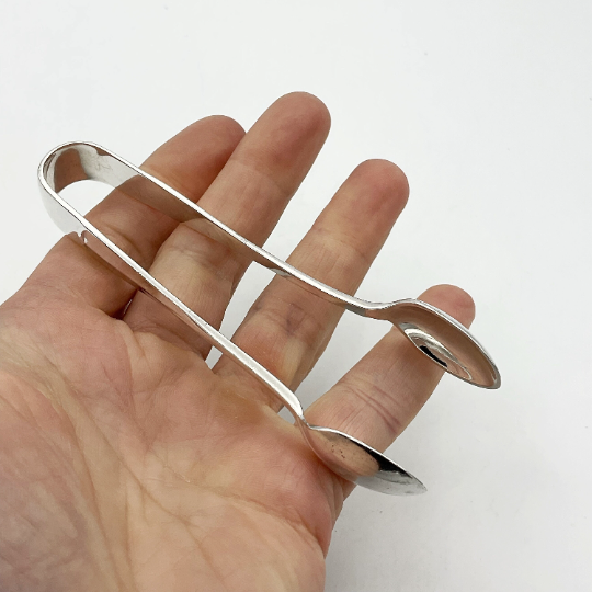 silver plated vintage sugar nips held in a hand