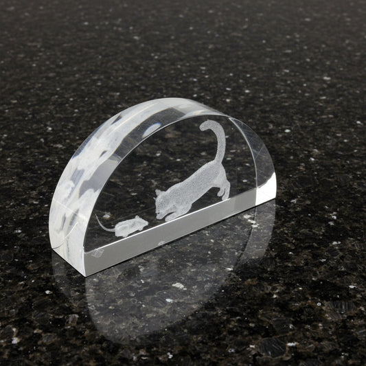 Clear crystal with cat and mouse design on a black surface