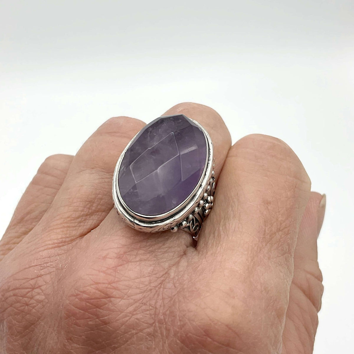 Large purple amethyst sterling silver ring featuring a prominent amethyst gemstone set in a detailed silver band.