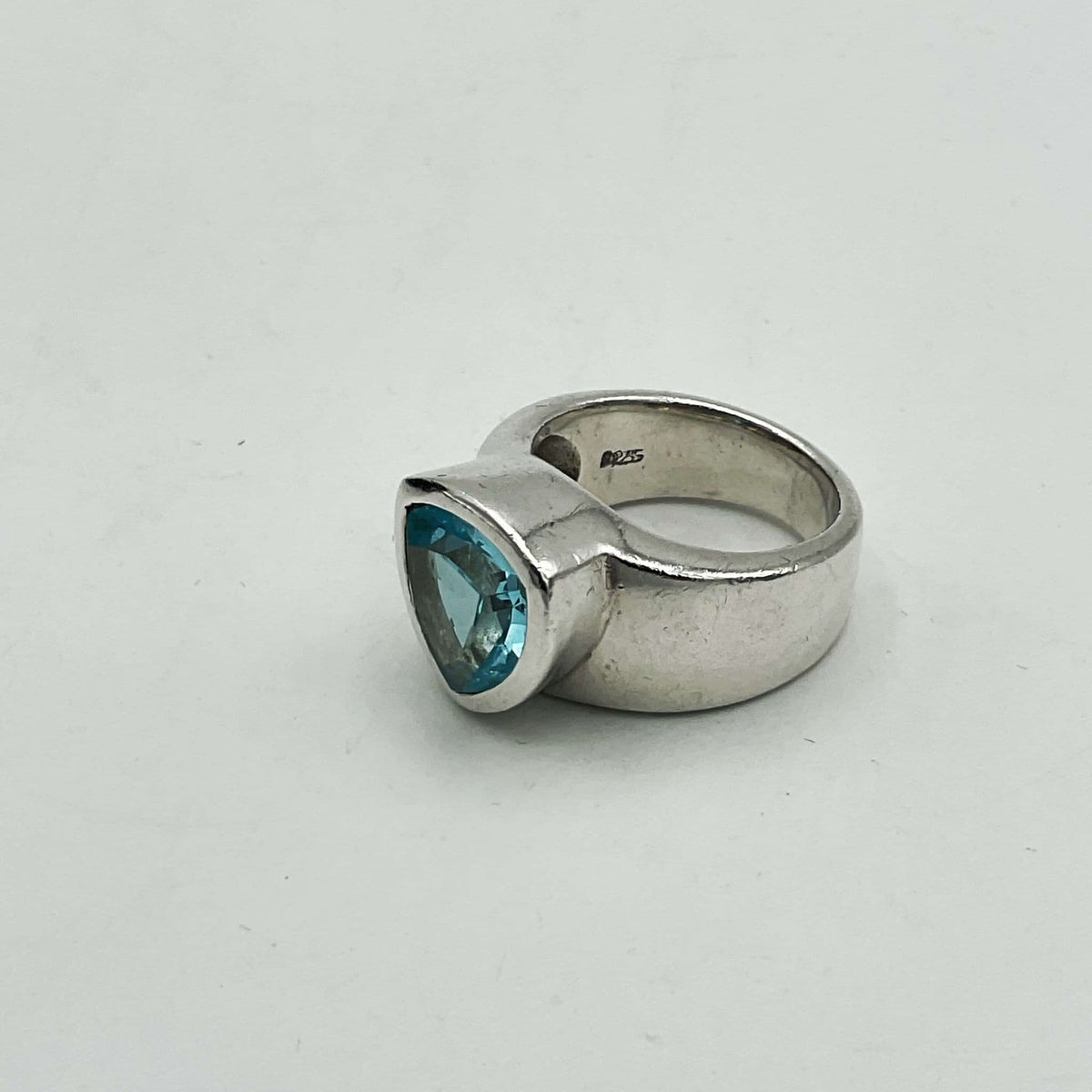 Light blue topaz silver ring by Beeches Vintage featuring a vibrant aquamarine gemstone and intricate silver band design.
