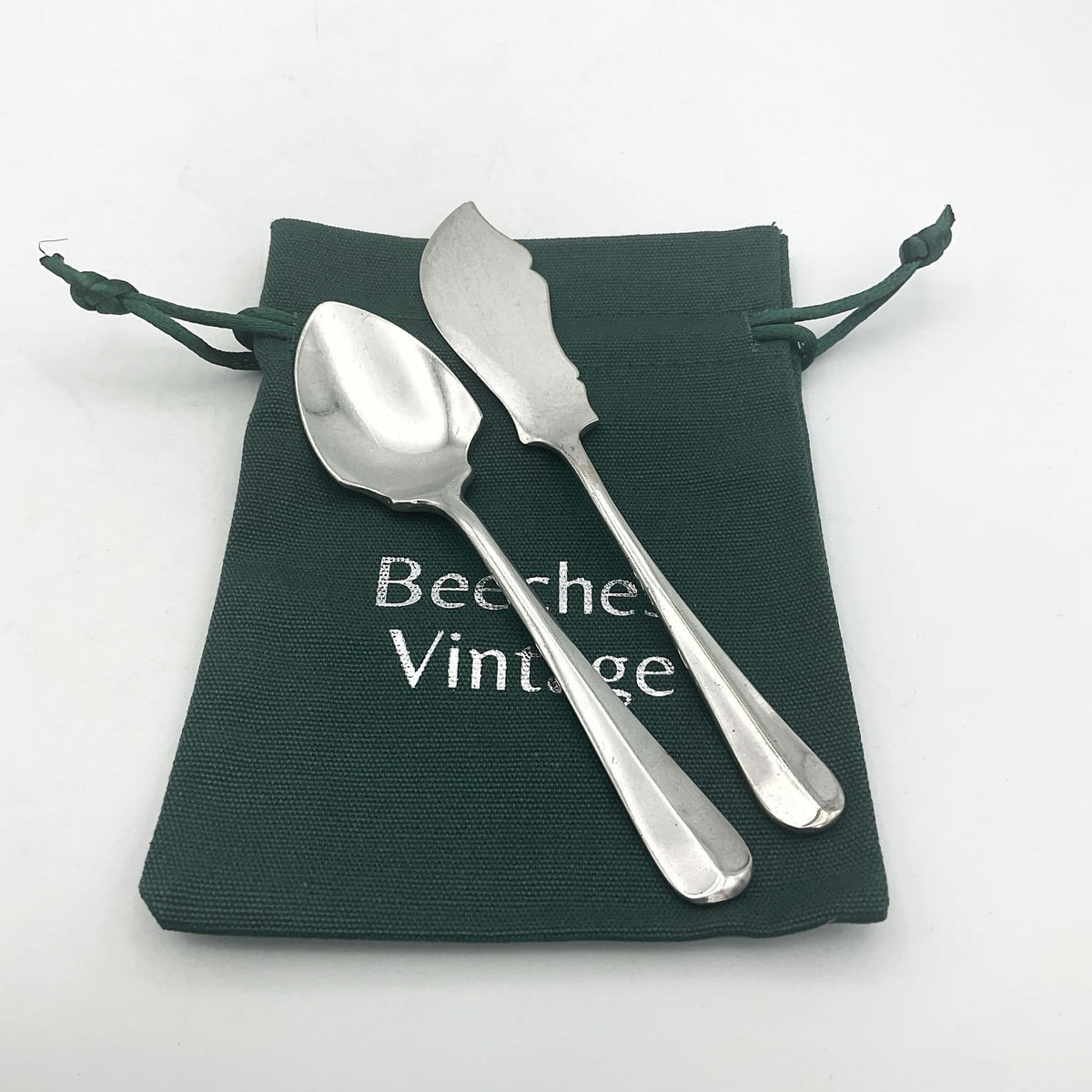 Mappin & Webb 1930s vintage butter knife and jam spoon set by Beeches Vintage, with ornate silver handles and detailed craftsmanship.