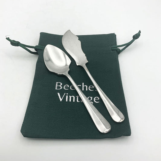 Mappin & Webb 1930s vintage butter knife and jam spoon set by Beeches Vintage, with ornate silver handles and detailed craftsmanship.