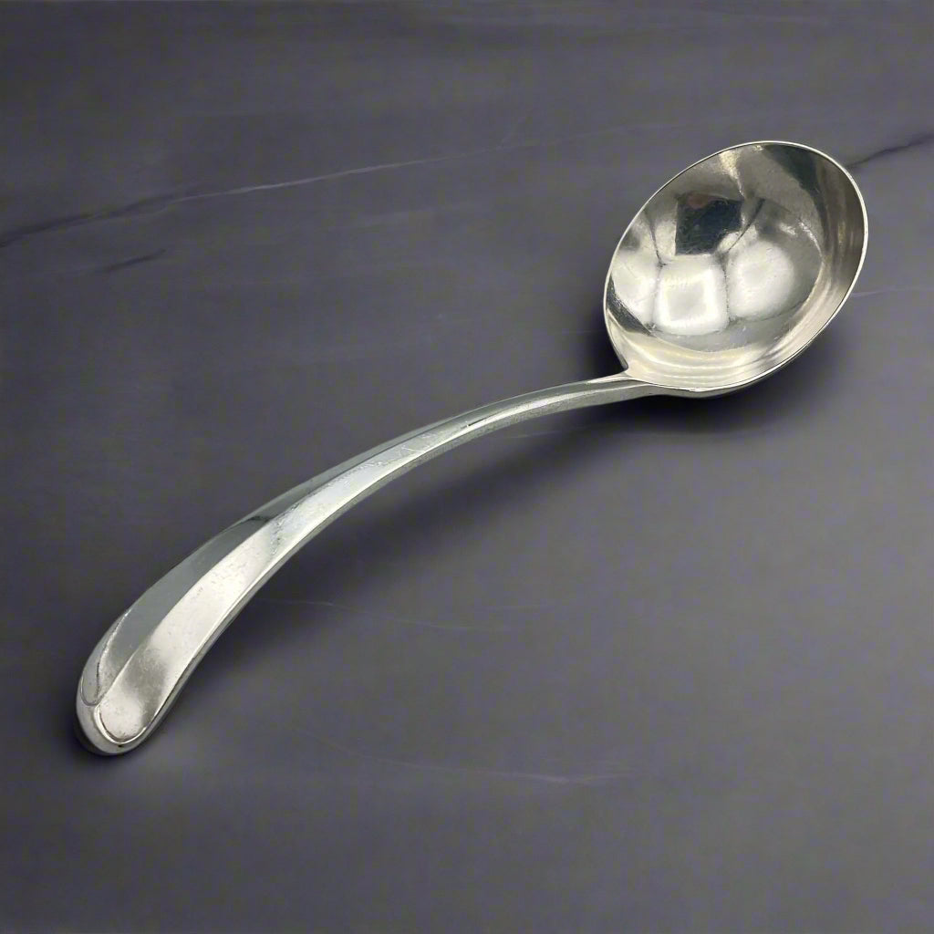 Silver ladle on a dark marble surface