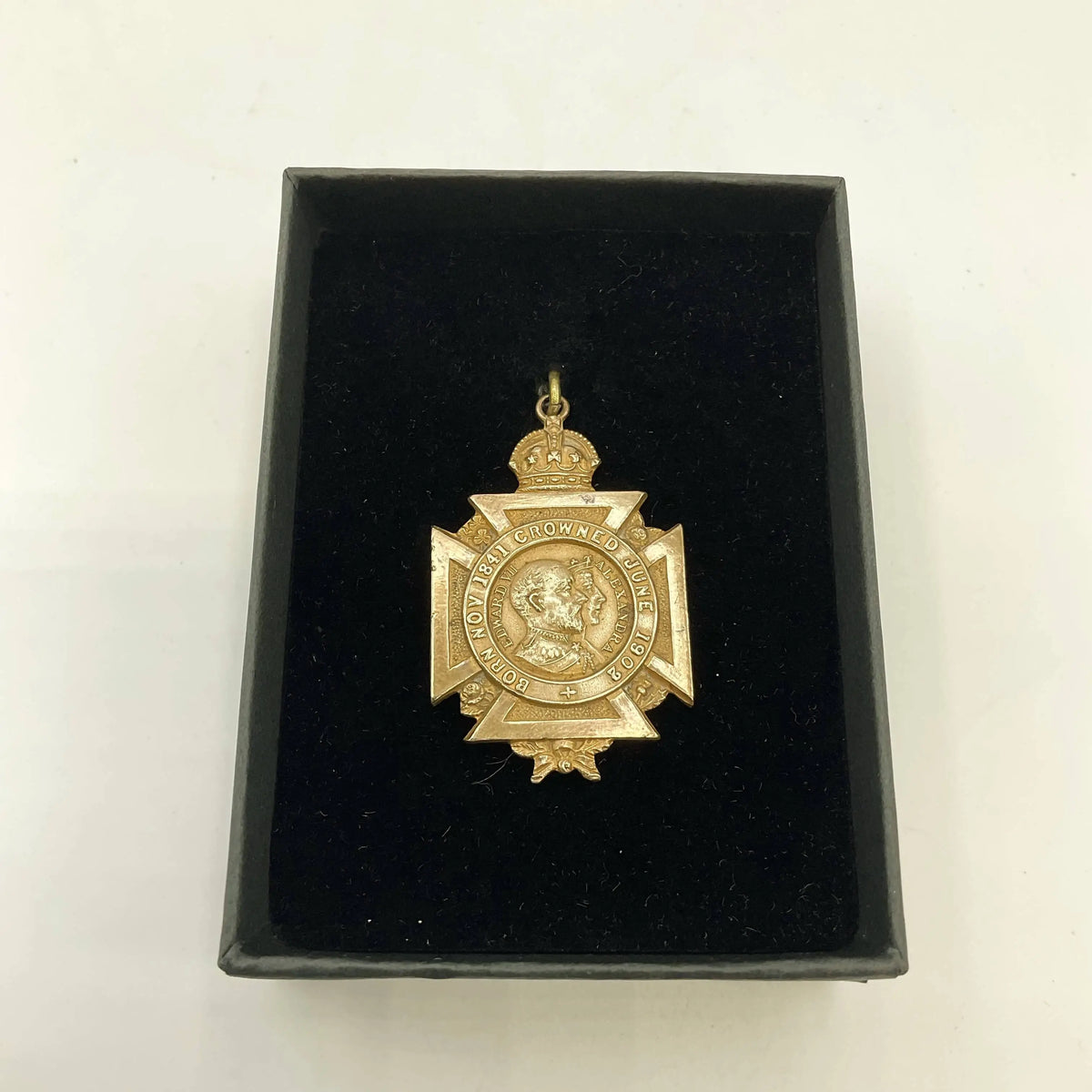 Gold medal with a crown in a black box on a white background