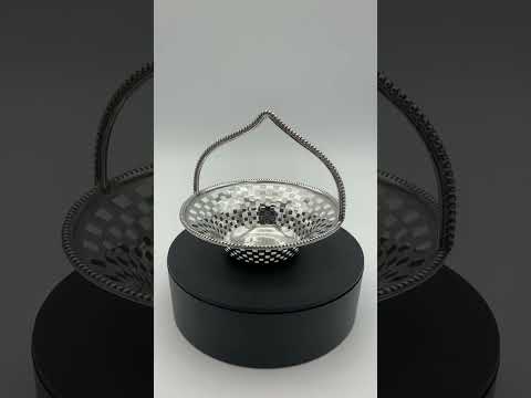 Antique Silver basket with handle on turntable rotating to see all sides of the basket.