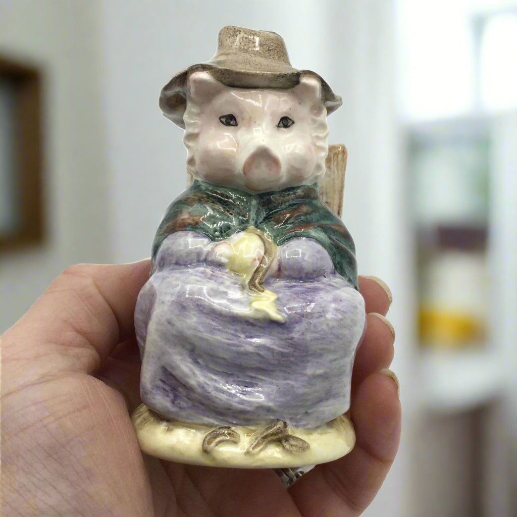 pig figurine held in hand with room in background