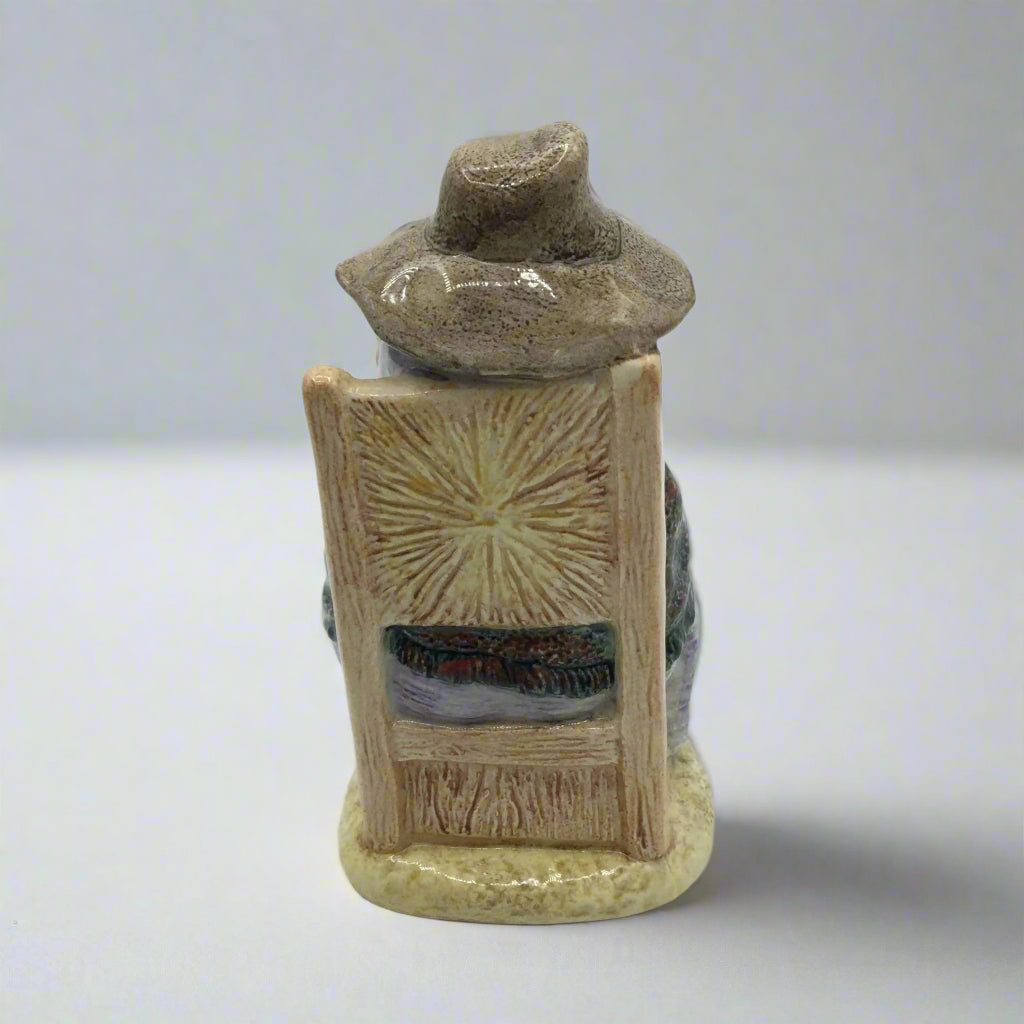 back of figurine on a chair on a white table