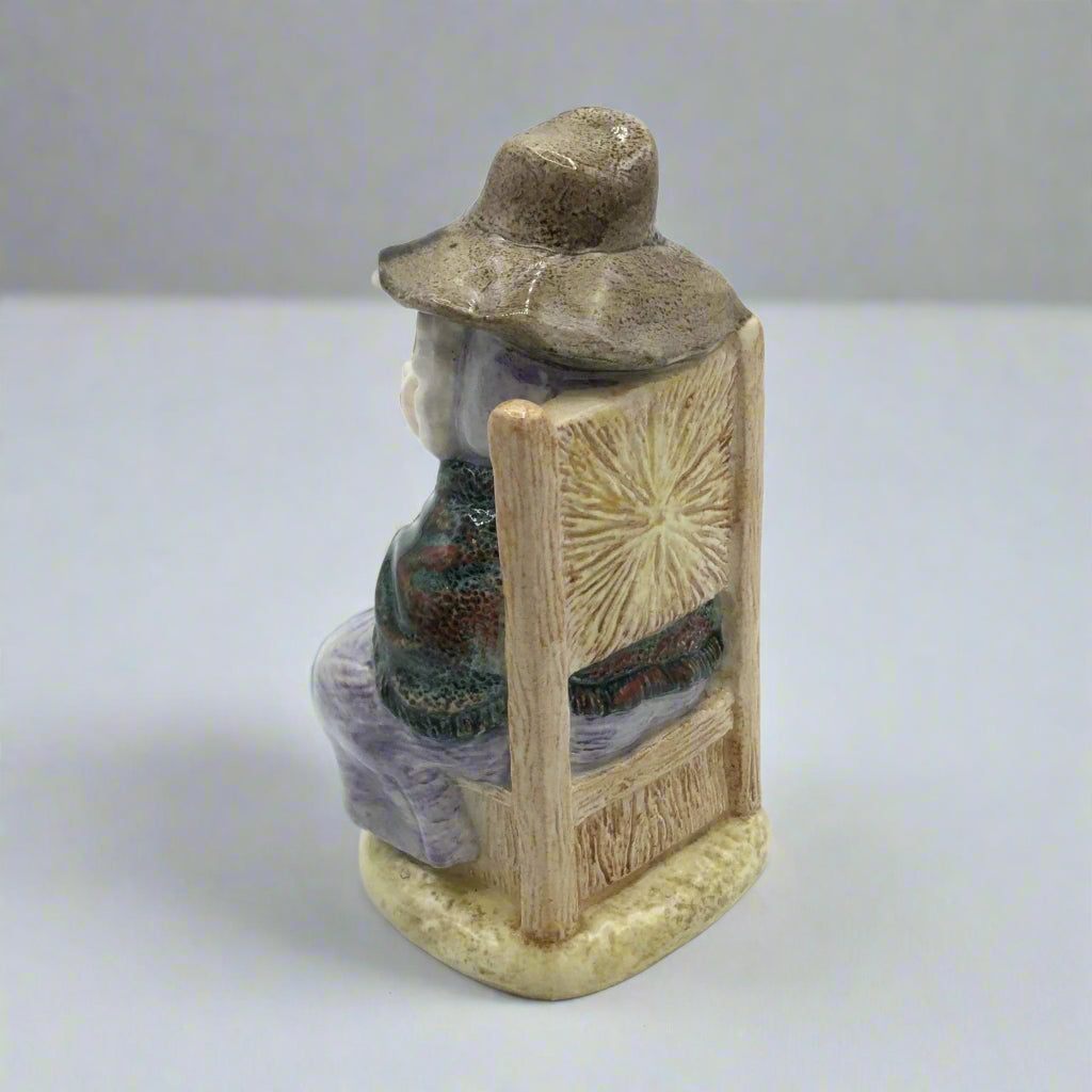 back of figurine on a chair on a white table
