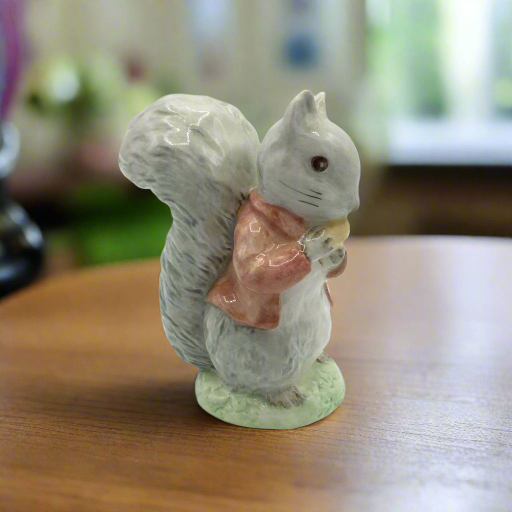 squirrel figurine eating a nut on wood table with blurred background