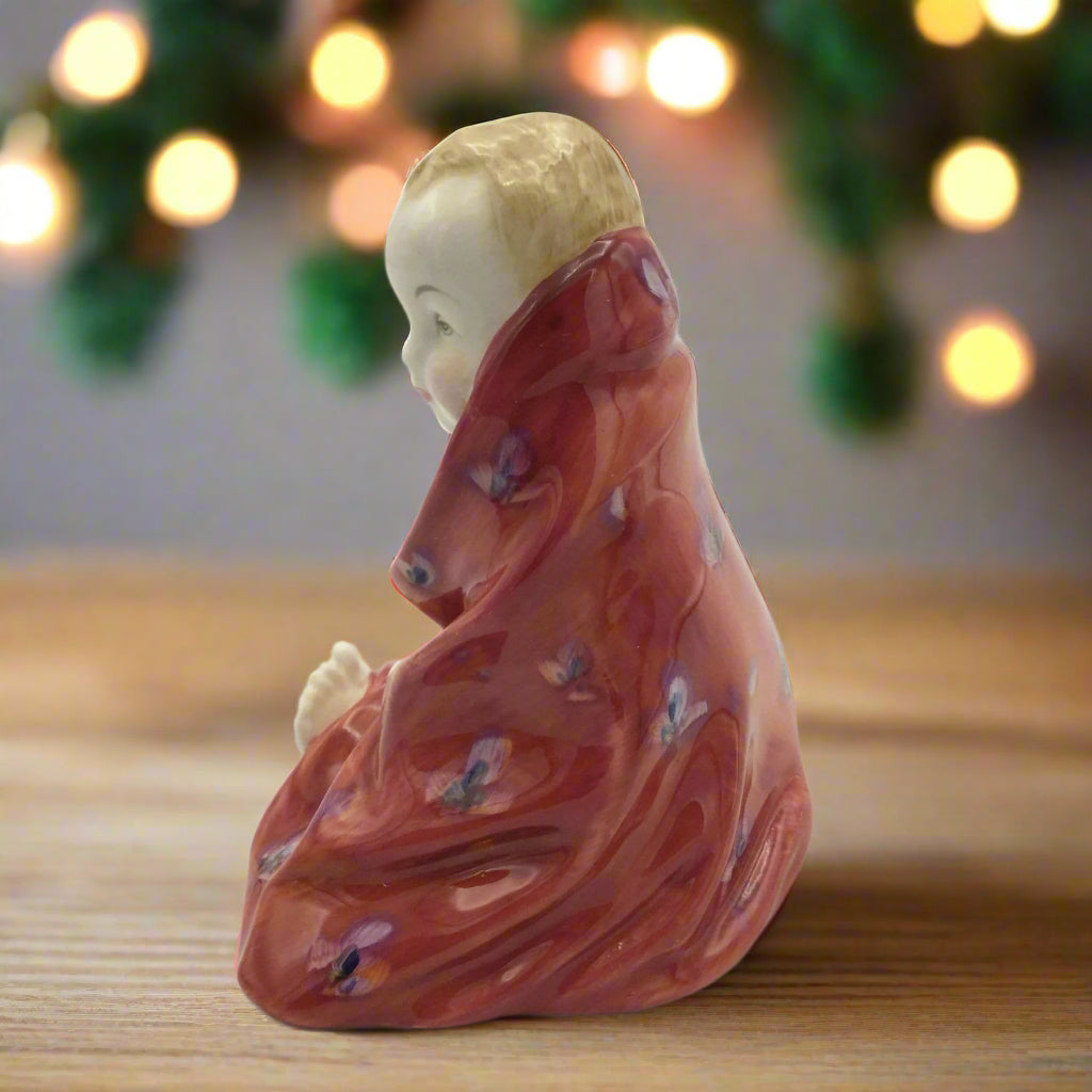 side view of ornament of bot wrapped in towel on a table with ornaments in the background