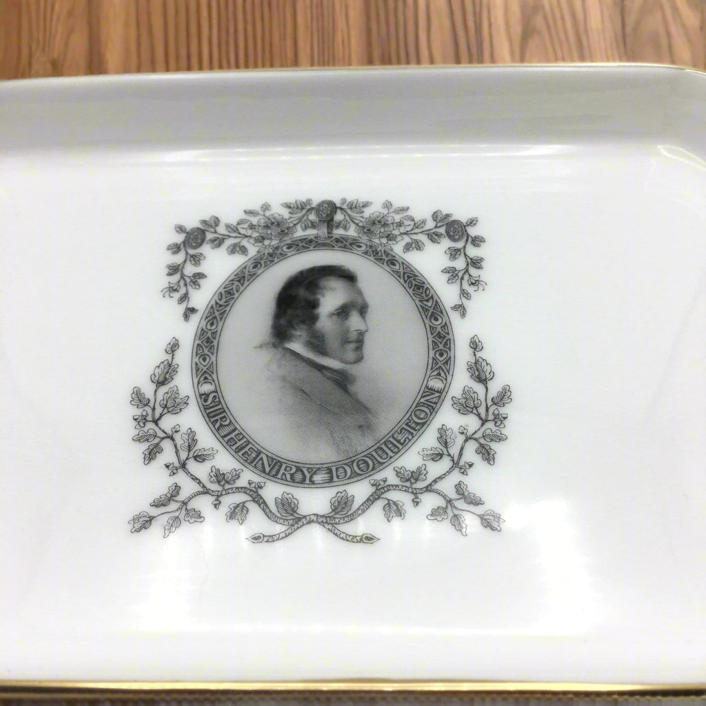 Sir Henry Doulton design in centre of china tray on a wood table