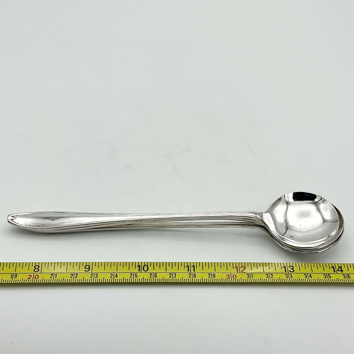 Set of silver-plated long-handled dessert spoons by Beeches Vintage, showing elegant, shiny utensils with ornate handles.